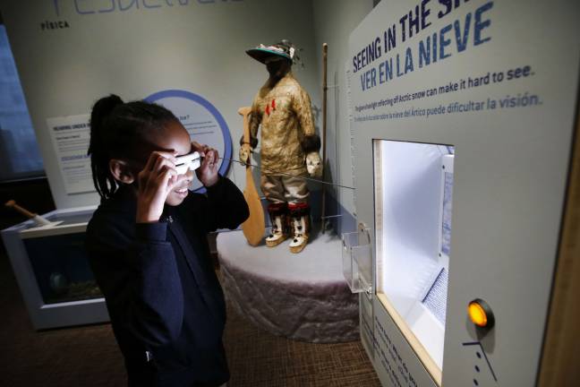 A fifth-grade student from New York City Public School 276 tries out Native American snow goggles at the imagiNATIONS Activity Center grand opening ceremony, Thursday, May 17, 2018. Photo: Jason DeCrow/AP Images for Smithsonian's National Museum of the American Indian